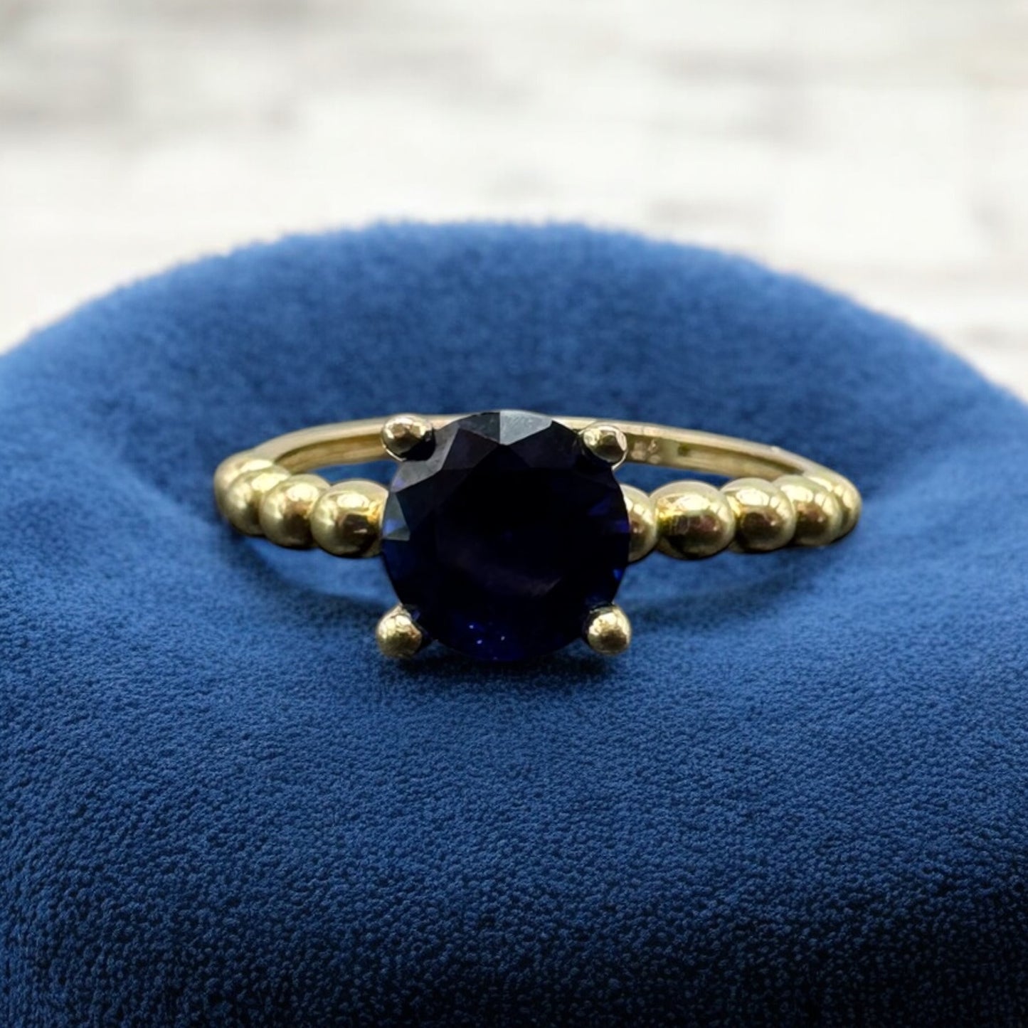 ANILLO CON PIEDRA AZUL Y CONTORNO DE BOLITAS EN ORO MEXICANO 10 K