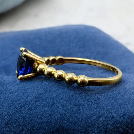 ANILLO CON PIEDRA AZUL Y CONTORNO DE BOLITAS EN ORO MEXICANO 10 K